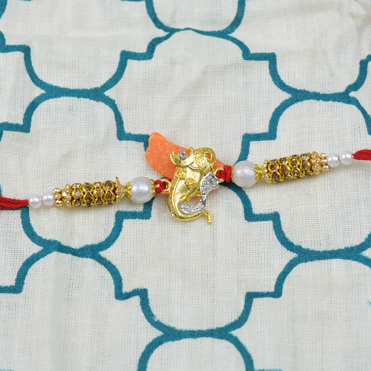 Golden Ganesha rakhi with pearls and diamonds