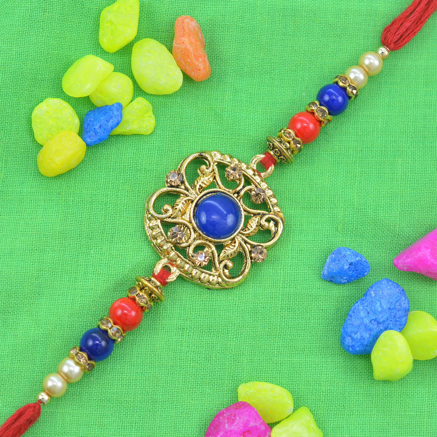 Beautiful Navy Blue Studded in Deep Golden Shape Pearl Rakhi with Red Silk Thread