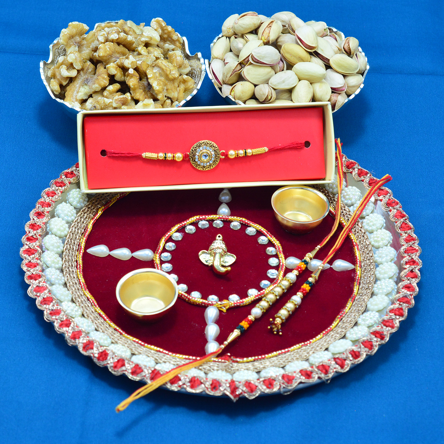 Akhrot and Pista Dry Fruits Hamper with Appealing Rakhis and Sacred Ganesha Special Pooja Thali