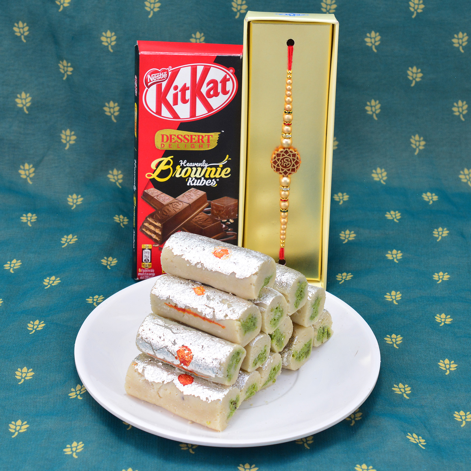 Gorgeous Eye Catching OM Rakhi with Delicious Kaju Roll with Yummy Nestle Kitkat Hammper