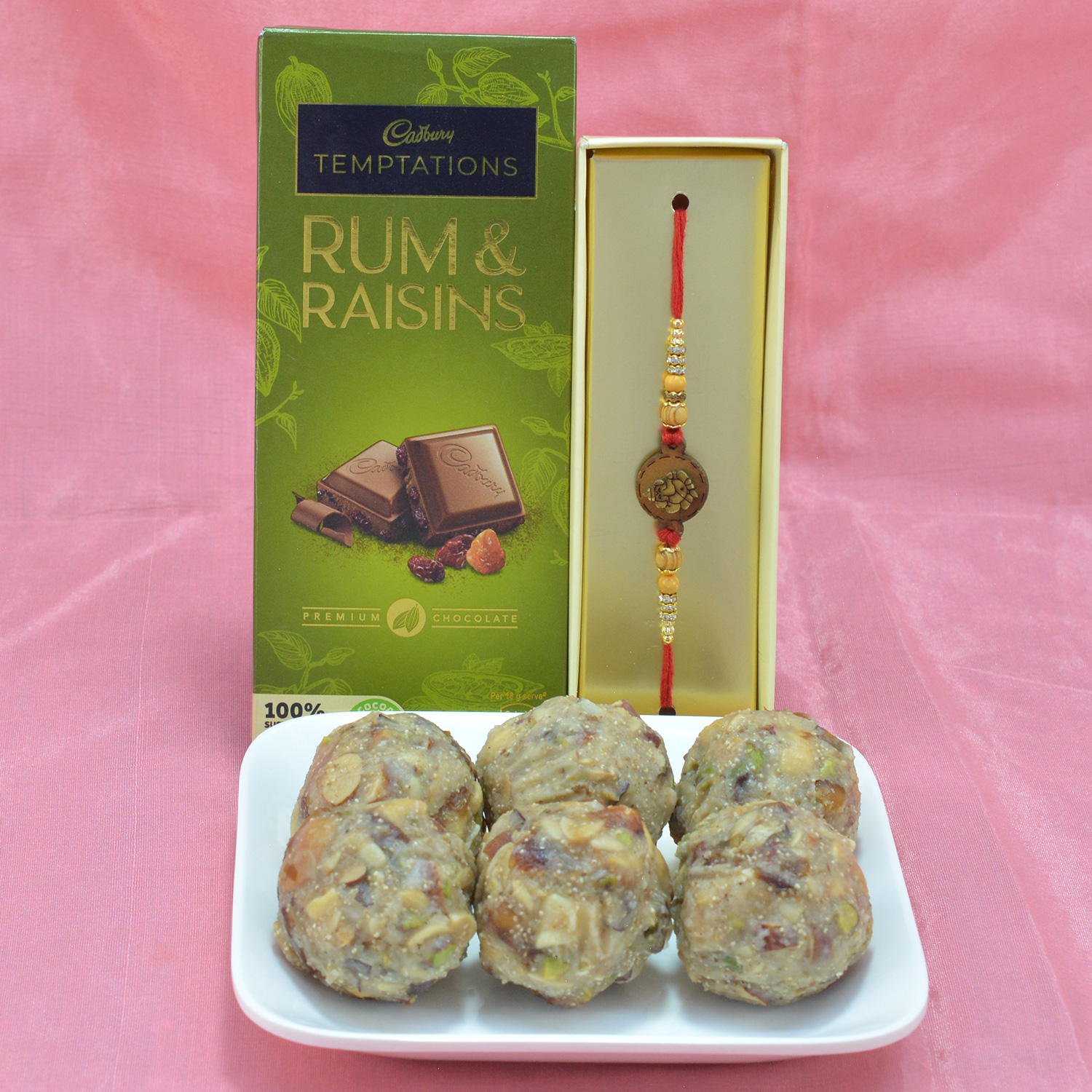 Palatable Dry Fruit Laddu with Tasteful Cadbury Temptations along with Attractive Rakhi Hamper