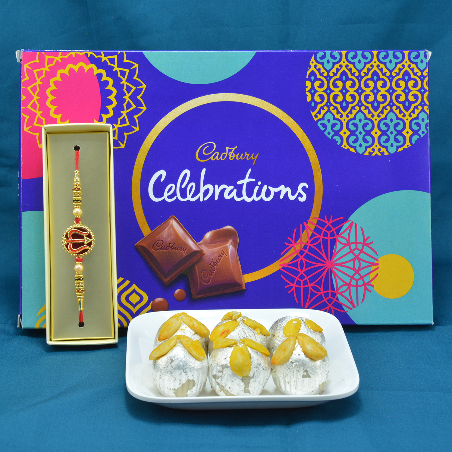 Amazing Divine Trishul Rakhi with Yummy Cadbury Celebrations along with Delicious Kaju Badam Laddu Hamper
