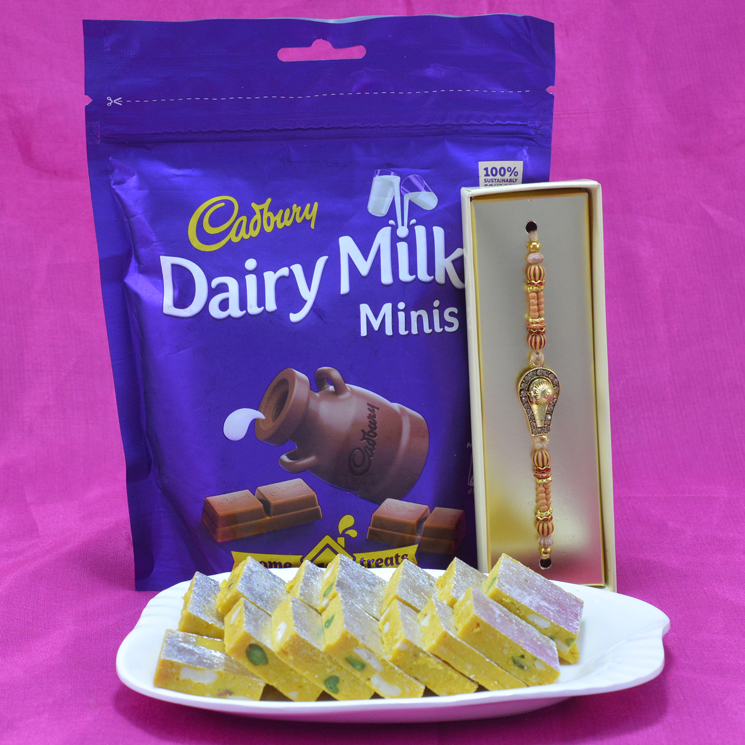 Beautiful Shivling Rakhi with Mouthwatering Kaju Pista Kesar Barfi along with Yummy Cadbury Dariy Milk Chocolate Hamper