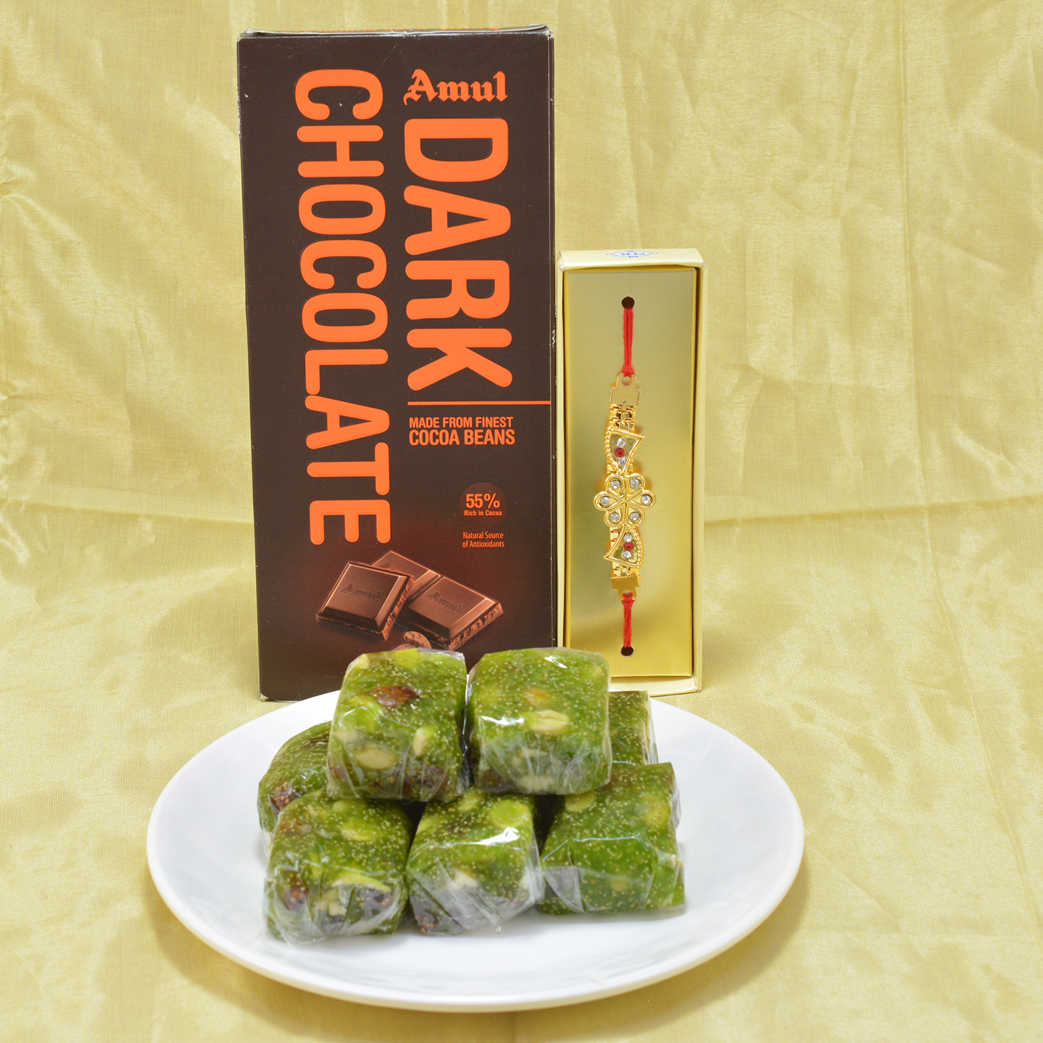 Succulent Kaju Anjeer Halwa with flavorsome Amul Dark Chocolate along with Diamond Stud Golden Theme Rakhi Hamper