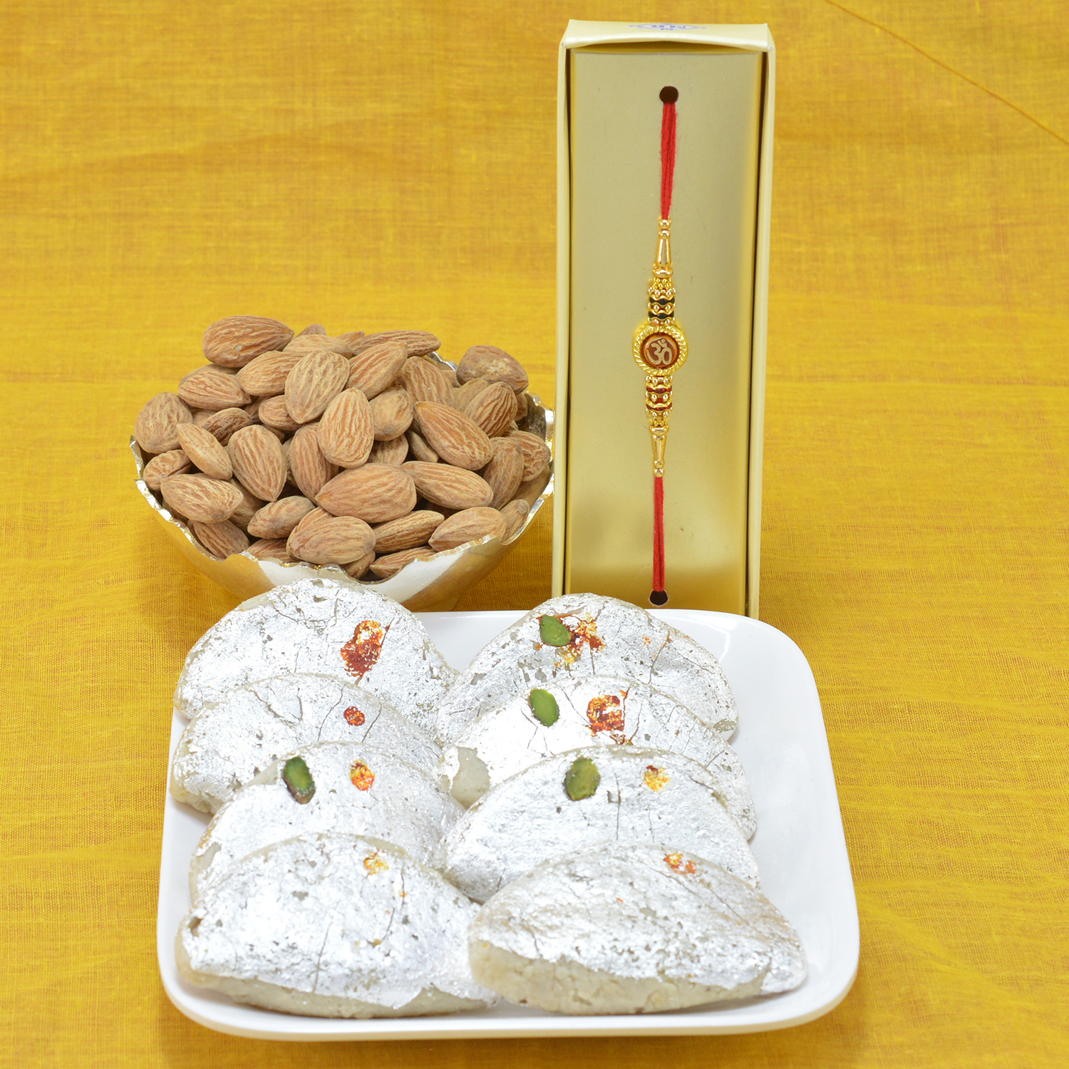 Superb Divine OM Rakhi with Flavorsome Kaju Gujia along with Tasteful Almond Dry Fruit Hamper