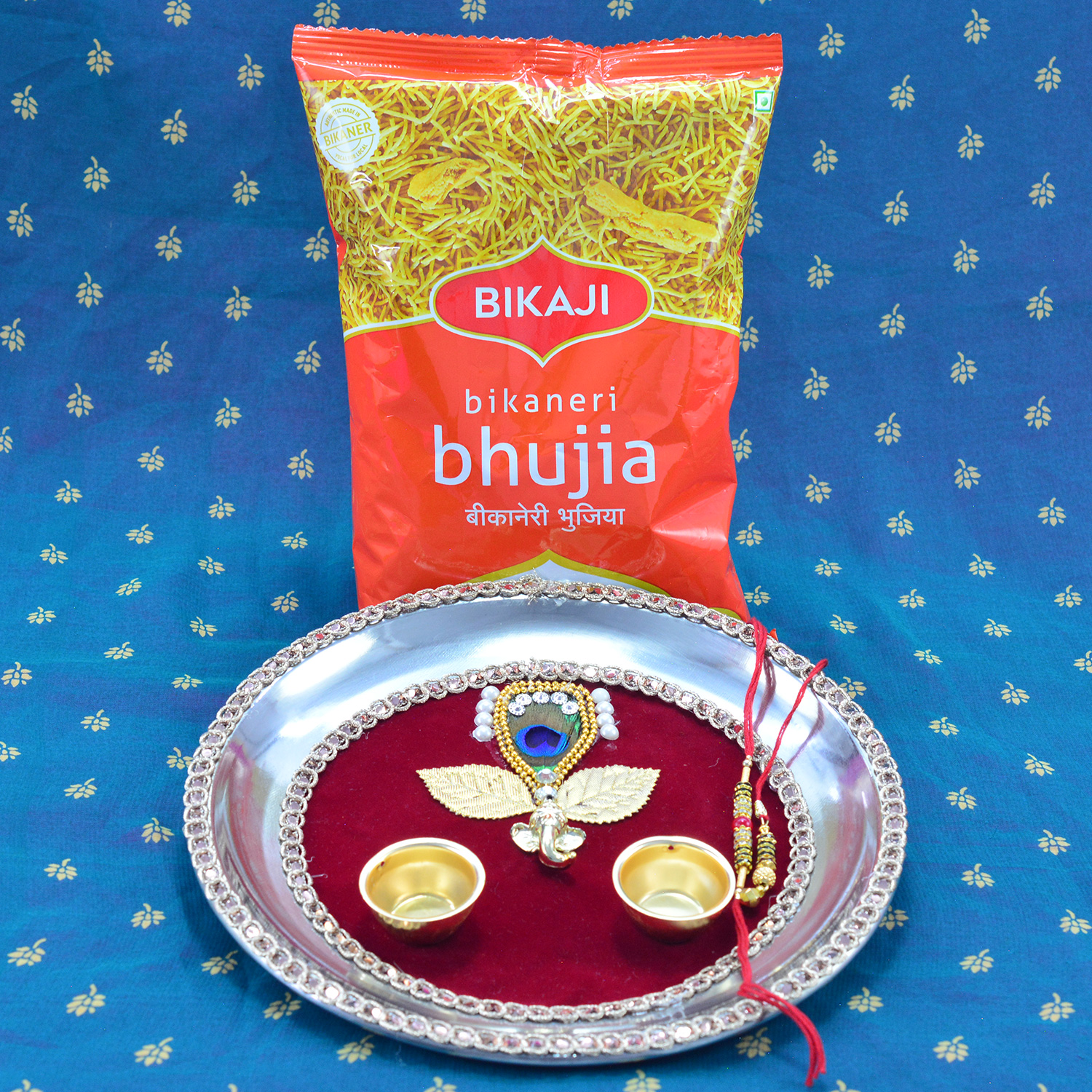 Bikaji Bhujia Small Packet Namkeen with Maroon Base Leaf and Ganesha Rakhi Pooja Thali for Raksha Bandhan