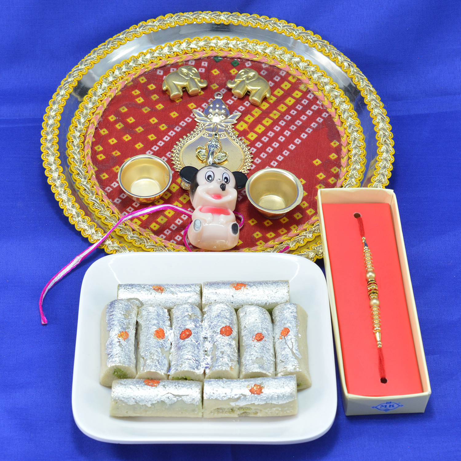 Gorgeous Ganesha Traditional Pooja Thali with Piquant Kaju Roll along with Beads Rakhi