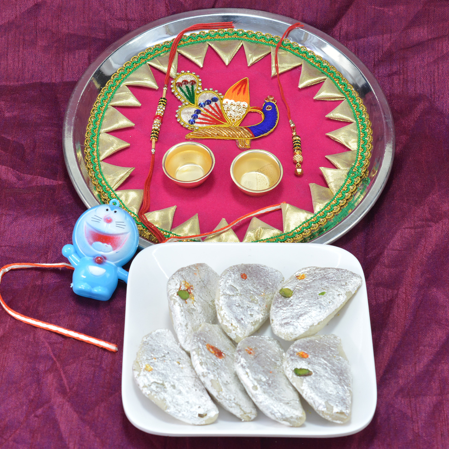 Astounding Peacock Crafted Pooja Thali with Delicious Kaju Gujia along with Doraemon Kids Rakhi