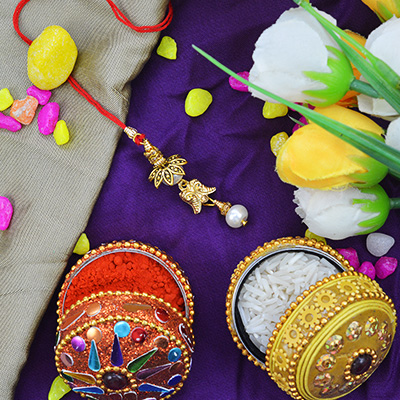Beads and Flower Leafs Hanging on a Red Threaded Lumba Rakhi