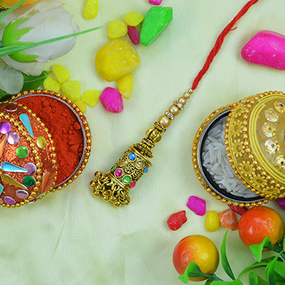 Mind-blowing Work On Golden Lumba Rakhi with Colorful Jewels