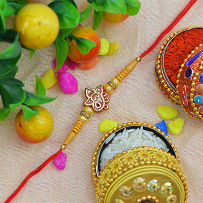 Alluring Shining Ganesh Moli-Dori Rakhi with Golden and Sandalwood Beads