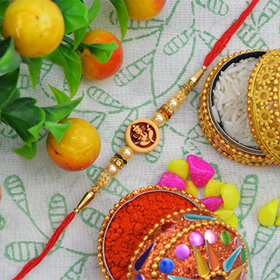 Awesome Well-Favoured Rounded Ganesh Moli Rakhi with Graceful Golden and Green Pearls