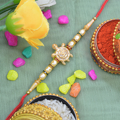 Beautiful Turtle on Golden OM Pearl Rakhi with Graceful Silk Thread