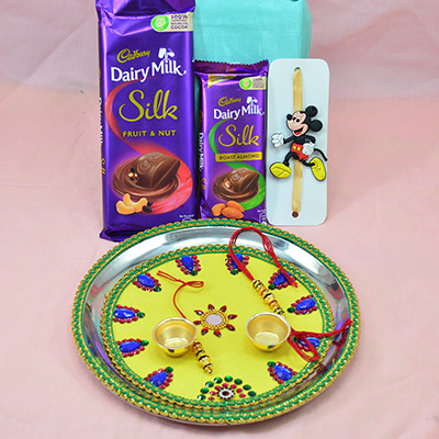 Dairy Milk Silk Chocolates with Mickey Mouse Kid Rakhi and Simple Elegant Looking Light Yellow Base Rakhi Thali