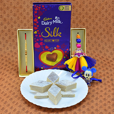 Rich Look Jewel Bhaiya Bhabhi Rakhi with Kids Rakhi and Luscious Kaju Katli with Yummy Cadbury Dairy Milk Silk Hamper