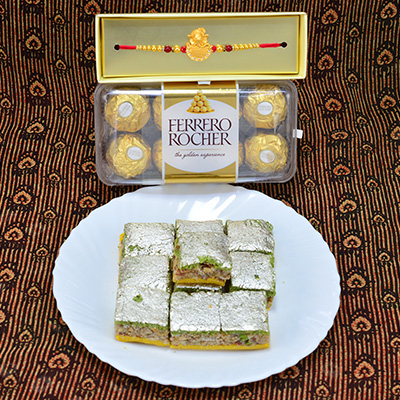 Magnificent Rudraksha Golden Theme Rakhi with Delicious Badam Pista Barfi along with 16 Pcs Luscious Ferrero Rocher Chocolate