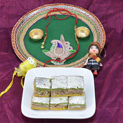 Stunning Crafted Pooja Thali with Mouthwatering Badam Pista Barfi along with 2 Kids Rakhi