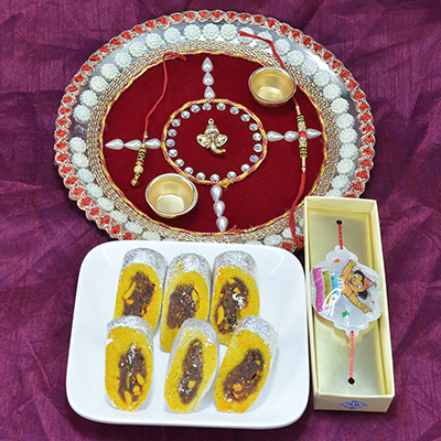 Astounding Ganesha Beads Pooja Thali with Savory Kaju Rajbahar Sweet along with Kids Rakhi Hamper