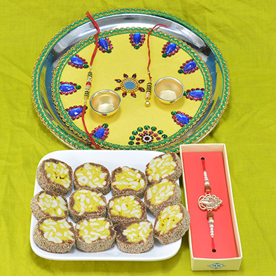 Astounding Mirror Flower Yellow Base Pooja Thali with Piquant Kaju Anjeer Pista Barfi along with Attractive Rakhi Hamper