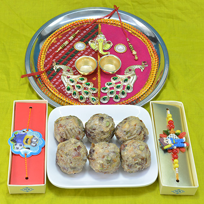 Astounding Traditional Divine Ganesha and Peacock Crafted Pooja Thali with Delicious Kaju Dry Fruit Laddu and Kids Rakhi Hamper