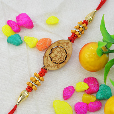 Wooden Studded Ganesh Sandalwood Rakhi with Golden and Red Pearls